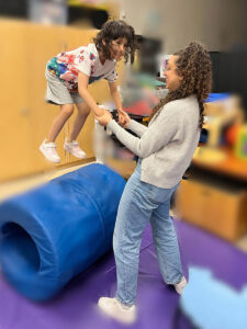 Olivia jumping with staff member